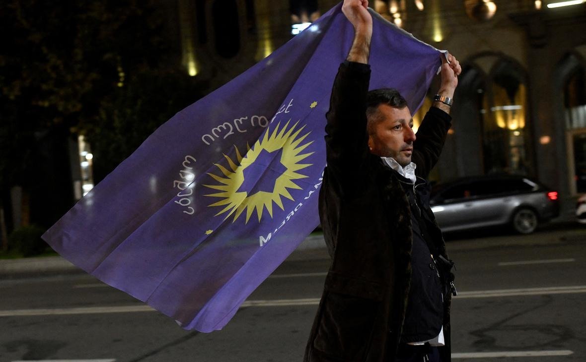 Мужчина с флагом «Грузинской мечты». Фото: Zurab Javakhadze / Reuters